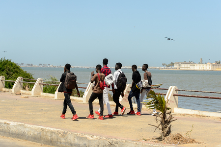 SAINT LOUIS, SENEGAL - APR 25, 2017: Unidentified Senegalese boys walk along the shore of the Atlantic ocean in Saint Louis, one of the biggest cities in Senegalのeditorial素材
