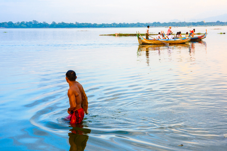 TAUNGTHAMAN LAKE, MYANMAR - AUG 25, 2016: Unidentified Burmese man comes out of the Taungthaman Lake near Amarapura, the former capital of Myanmarのeditorial素材