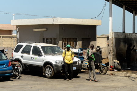 SAINT LOUIS, SENEGAL - APR 25, 2017: Unidentified Senegalese men stand near the cars in Saint Louis, one of the biggest cities in Senegalのeditorial素材