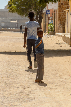 SAINT LOUIS, SENEGAL - APR 24, 2017: Unidentified Senegalese little boy stands in the middle of the road and opens his mouth in Saint Louis, one of the biggest cities in Senegalのeditorial素材