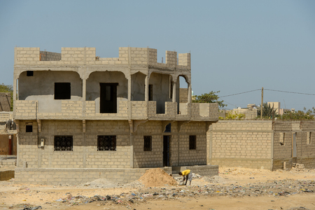 ROAD TO LAMPOUL, SENEGAL - APR 23, 2017: Unidentified Senegalese man bends down to put up a bag. Still many people in Senegal live in povertyのeditorial素材