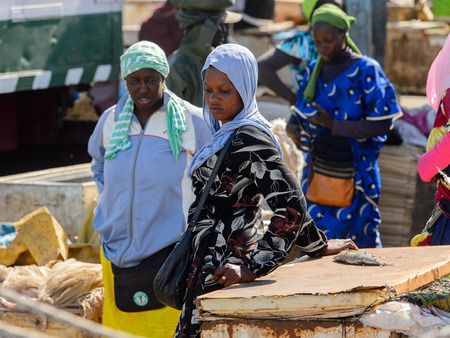 SAINT LOUIS, SENEGAL - APR 24, 2017: Unidentified Senegalese women in headscarves buy goods at the local market of Saint Louis, Senegalのeditorial素材