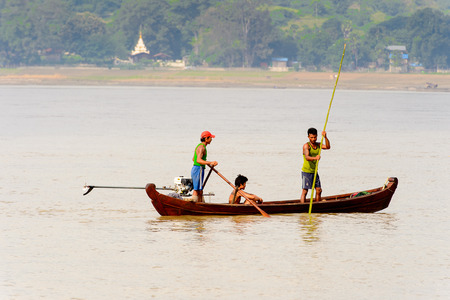 IRRAWADDY RIVER, MYANMAR - AUG 26, 2016: Unidentified Burmese peope in a wooden boat over the Irrawaddy River, Myanmar. It's largest rive and most important commercial waterwayのeditorial素材