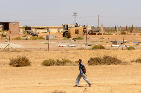 ROAD TO LAMPOUL, SENEGAL - APR 23, 2017: Unidentified Senegalese little boy with backpack walks along the street. Still many people in Senegal live in povertyのeditorial素材