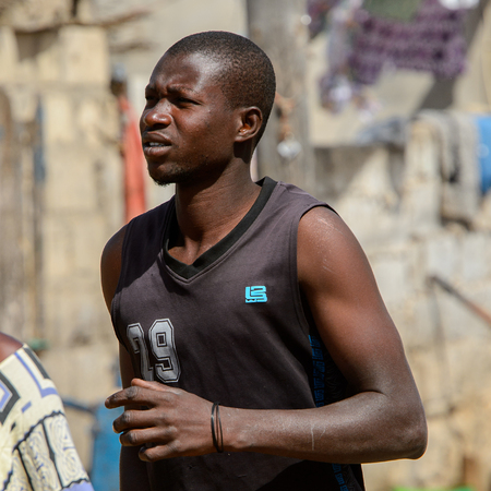 KAYAR, SENEGAL - APR 27, 2017: Unidentified Senegalese man walks along the street at the local market of Kayar, Senegal.のeditorial素材