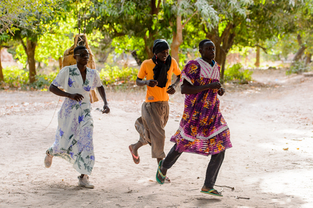 Kaguit vil., SENEGAL - APR 30, 2017: Unidentified Diola men wear skirts and move during a traditional dance Kumpo in a Sacred Forest near Kaguit villageのeditorial素材