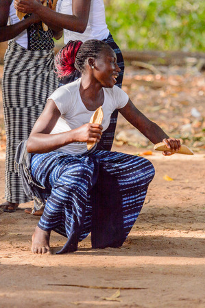 Kaguit vil., SENEGAL - APR 30, 2017: Unidentified Diola woman with braids squats during a traditional dance Kumpo in a Sacred Forest near Kaguit villageのeditorial素材