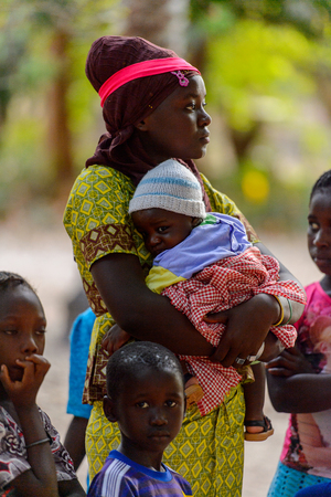 OUSSOUYE, SENEGAL - APR 30, 2017: Unidentified Senegalese woman holds a baby girl in the Sacred Forest near Kaguit villageのeditorial素材