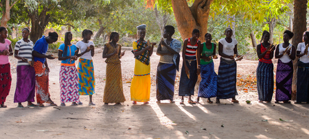 Kaguit vil., SENEGAL - APR 30, 2017: Unidentified Diola women in colored clothes hold a special attributes during a traditional dance Kumpo in a Sacred Forest near Kaguit villageのeditorial素材