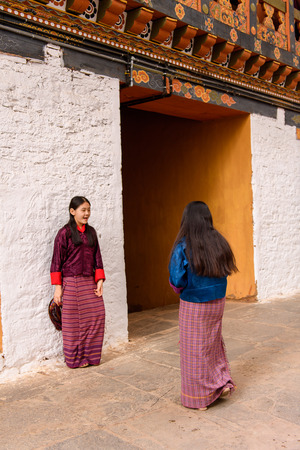 TRIMPHU, BHUTAN - MAR 8, 2017: Unidentified Ngalops twowomen stand near the building. Ngalops is one of the most populous ethnic groups of Bhutanのeditorial素材