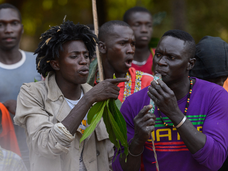 Kaguit vil., SENEGAL - APR 30, 2017: Unidentified Diola man plays on a pipe during a traditional dance Kumpo in a Sacred Forest near Kaguit villageのeditorial素材