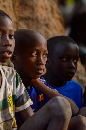 OUSSOUYE, SENEGAL - APR 30, 2017: Unidentified Senegalese little boys sit near the tree  in the Sacred Forest near Kaguit villageのeditorial素材