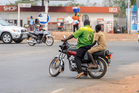PIRA, BENIN - JAN 12, 2017: Unidentified Beninese people ride a motorcycle. Benin people suffer of poverty due to the bad economy.のeditorial素材