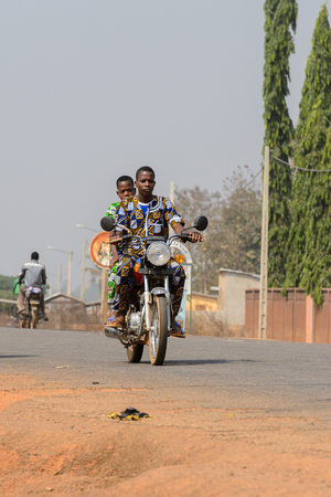 BOHICON, BENIN - JAN 12, 2017: Unidentified Beninese people ride a motorcycle at the local market. Benin people suffer of poverty due to the bad economy.のeditorial素材