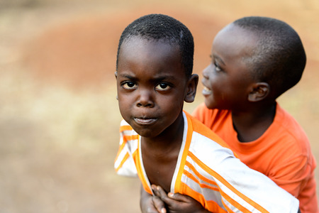 MASSIF KABYE, TOGO - JAN 13, 2017: Unidentified Togolese  little boy carries his friend in the...