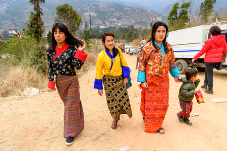 TRIMPHU, BHUTAN - MAR 8, 2017: Unidentified Ngalops people walk aong the road. Ngalops is one of the most populous ethnic groups of Bhutanのeditorial素材