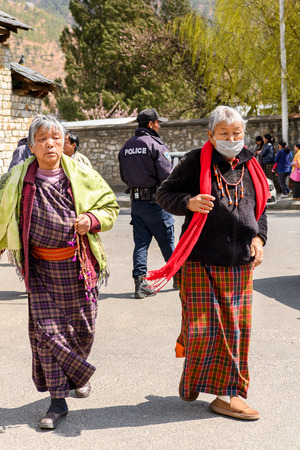 TRIMPHU, BHUTAN - MAR 8, 2017: Unidentified Ngalops people walk along the street. Ngalops is one of the most populous ethnic groups of Bhutanのeditorial素材