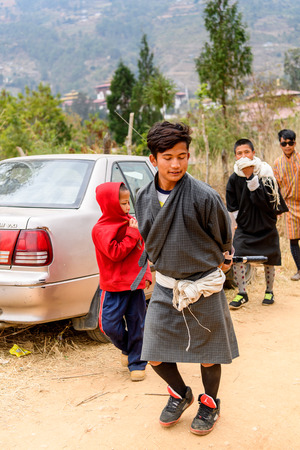 TRIMPHU, BHUTAN - MAR 8, 2017: Unidentified Ngalops people walk aong the road. Ngalops is one of the most populous ethnic groups of Bhutanのeditorial素材