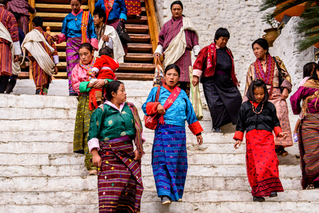 TRIMPHU, BHUTAN - MAR 8, 2017: Unidentified Ngalops people in traditional clothes walk on the street. Ngalops is one of the most populous ethnic groups of Bhutanのeditorial素材