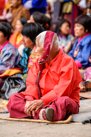 TRIMPHU, BHUTAN - MAR 8, 2017: Unidentified Ngalops old woman sits on the floor in the crowd. Ngalops is one of the most populous ethnic groups of Bhutanのeditorial素材