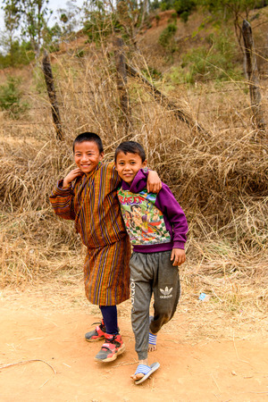 TRIMPHU, BHUTAN - MAR 8, 2017: Unidentified Ngalops boys in traditional clothes smile. Ngalops is one of the most populous ethnic groups of Bhutanのeditorial素材