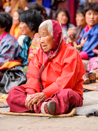 TRIMPHU, BHUTAN - MAR 8, 2017: Unidentified Ngalops old woman sits on the floor in the crowd. Ngalops is one of the most populous ethnic groups of Bhutanのeditorial素材