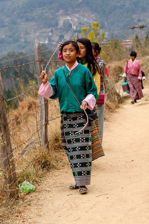 TRIMPHU, BHUTAN - MAR 8, 2017: Unidentified Ngalops people walk along the road. Ngalops is one of the most populous ethnic groups of Bhutanのeditorial素材