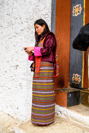 TRIMPHU, BHUTAN - MAR 8, 2017: Unidentified Ngalops woman in traditional clothes stands on the street. Ngalops is one of the most populous ethnic groups of Bhutanのeditorial素材