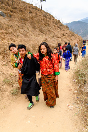 TRIMPHU, BHUTAN - MAR 8, 2017: Unidentified Ngalops people in traditional clothes walk along the street. Ngalops is one of the most populous ethnic groups of Bhutanのeditorial素材