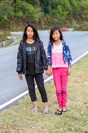 TRIMPHU, BHUTAN - MAR 8, 2017: Unidentified Ngalops two girls stand beside the road. Ngalops is one of the most populous ethnic groups of Bhutanのeditorial素材