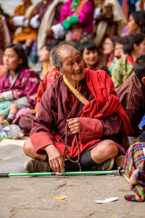 TRIMPHU, BHUTAN - MAR 8, 2017: Unidentified Ngalops old man sits on the floor in the crowd. Ngalops is one of the most populous ethnic groups of Bhutanのeditorial素材
