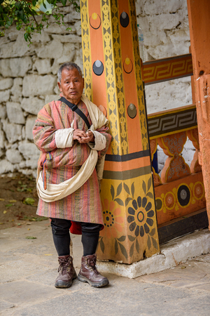 TRIMPHU, BHUTAN - MAR 8, 2017: Unidentified Ngalops man in traditional clothes stands near the column. Ngalops is one of the most populous ethnic groups of Bhutanのeditorial素材