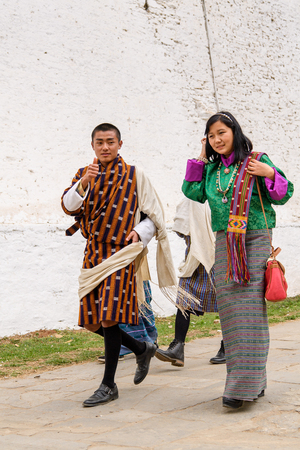 TRIMPHU, BHUTAN - MAR 8, 2017: Unidentified Ngalops people in traditional clothes walk along the street. Ngalops is one of the most populous ethnic groups of Bhutanのeditorial素材