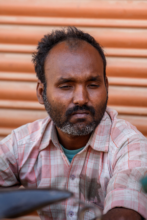 KATMANDU, NEPAL - MAR 6, 2017: Unidentified Chhetri man with beard in plaid shirt looks down. Chhetris is the most populous ethnic group of Nepalのeditorial素材