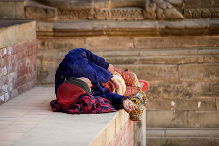 KATMANDU, NEPAL - MAR 6, 2017: Unidentified Chhetri woman sleeps on the street. Chhetris is the most populous ethnic group of Nepalのeditorial素材
