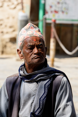 KATMANDU, NEPAL - MAR 6, 2017: Unidentified Chhetri serious man in a hat and traditional clothes frowns. Chhetris is the most populous ethnic group of Nepalのeditorial素材