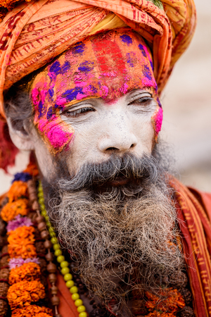KATMANDU, NEPAL - MAR 6, 2017: Unidentified Chhetri old man with beard and painted face wears orange costume, a hat and different necklaces. Chhetris is the most populous ethnic group of Nepalのeditorial素材