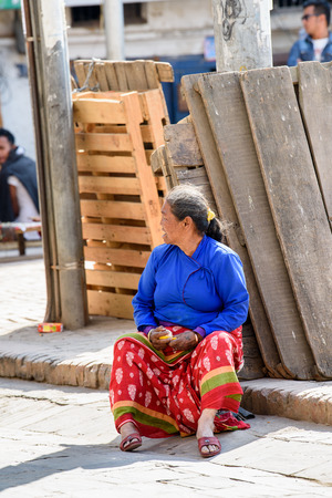 KATMANDU, NEPAL - MAR 6, 2017: Unidentified Chhetri woman sits on the ground. Chhetris is the most populous ethnic group of Nepalのeditorial素材