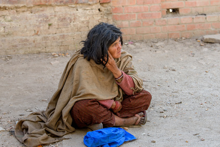 KATMANDU, NEPAL - MAR 6, 2017: Unidentified Chhetri woman in long scarf and pants sits on the ground in lotus position. Chhetris is the most populous ethnic group of Nepalのeditorial素材