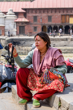 KATMANDU, NEPAL - MAR 6, 2017: Unidentified Chhetri woman in traditional clothes sells necklaces. Chhetris is the most populous ethnic group of Nepalのeditorial素材