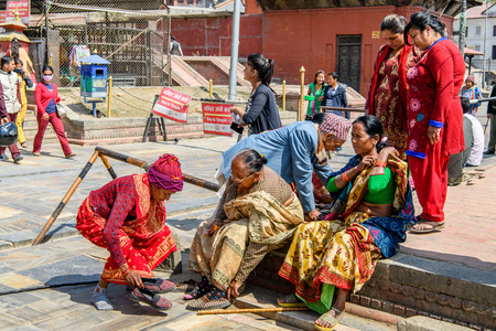 KATMANDU, NEPAL - MAR 6, 2017: Unidentified Chhetri women in traditional clothes take off their shoes. Chhetris is the most populous ethnic group of Nepalのeditorial素材