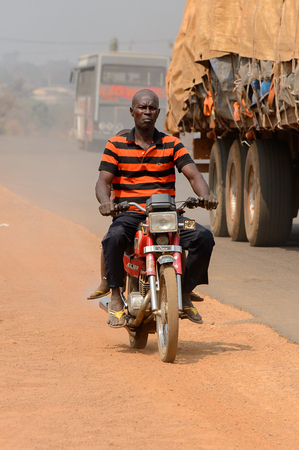 PIRA, BENIN - JAN 12, 2017: Unidentified Beninese man rides a motorcycle. Benin people suffer of poverty due to the bad economy.のeditorial素材