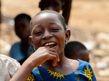 BOHICON, BENIN - JAN 12, 2017: Unidentified Beninese girl in colored shirt shows her teeth at the local market. Benin children suffer of poverty due to the bad economy.のeditorial素材