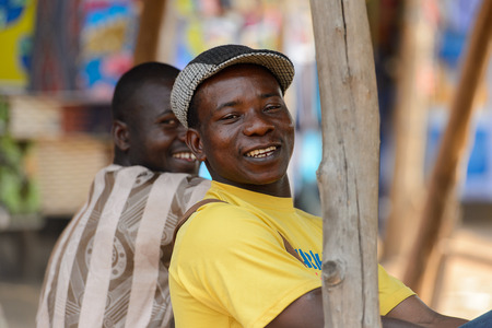 BOHICON, BENIN - JAN 12, 2017: Unidentified Beninese man in yellow shirt and a cap smiles at the...