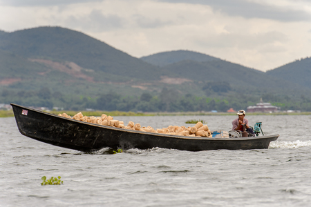 INLE LAKE, MYANMAR - AUG 30, 2016: Unidentified Burmese man in bamboo boat sails over the Inle Sap,a freshwater lake located in the Nyaungshwe Township of Taunggyi District of Shan State, Myanmarのeditorial素材