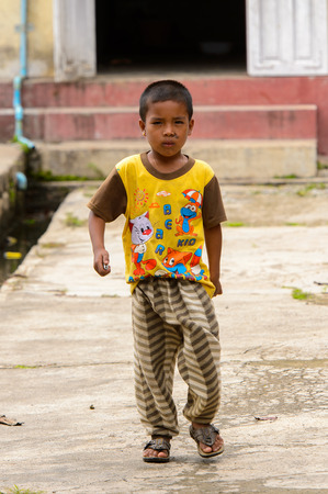 NYAUNGSHWE, MYANMAR - AUG 30, 2016: Unidentified Burmese little boy walks in the street. 68 per cent of Myanma people belong to Bamar ethnic groupのeditorial素材
