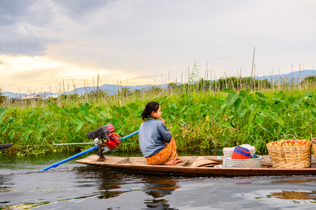 INLE LAKE, MYANMAR - AUG 30, 2016: Unidentified Burmese girl in bamboo boat sails over the Inle Sap,a freshwater lake located in the Nyaungshwe Township of Taunggyi District of Shan State, Myanmarのeditorial素材