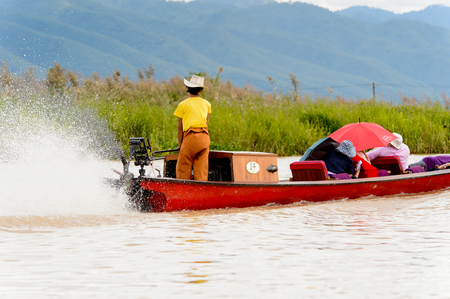 INLE LAKE, MYANMAR - AUG 30, 2016: Unidentified Burmese man in bamboo boat sails over the Inle Sap,a freshwater lake located in the Nyaungshwe Township of Taunggyi District of Shan State, Myanmarのeditorial素材