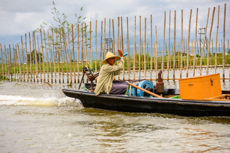 INLE LAKE, MYANMAR - AUG 30, 2016: Unidentified Burmese man in bamboo boat sails over the Inle Sap,a freshwater lake located in the Nyaungshwe Township of Taunggyi District of Shan State, Myanmarのeditorial素材