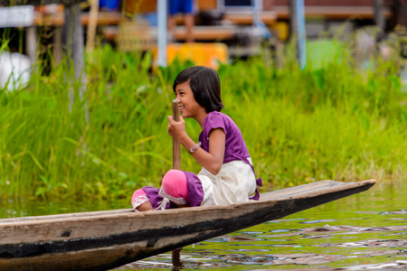 INLE LAKE, MYANMAR - AUG 30, 2016: Unidentified Burmese girl in bamboo boat sails over the Inle Sap,a freshwater lake located in the Nyaungshwe Township of Taunggyi District of Shan State, Myanmarのeditorial素材